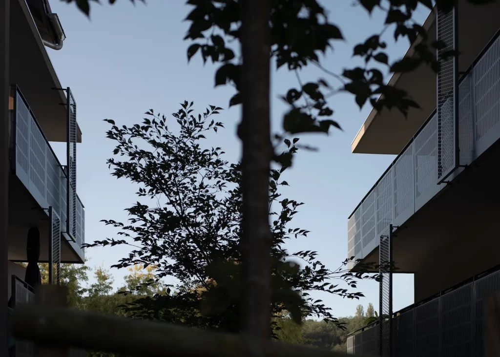 Complexe résidentiel moderne offrant des logements privés-aidés, caractérisé par une architecture innovante et des espaces verts intégrés