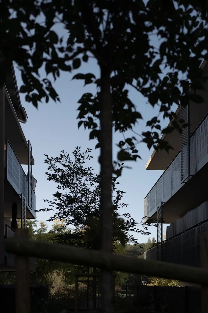 Complexe résidentiel moderne offrant des logements privés-aidés, caractérisé par une architecture innovante et des espaces verts intégrés