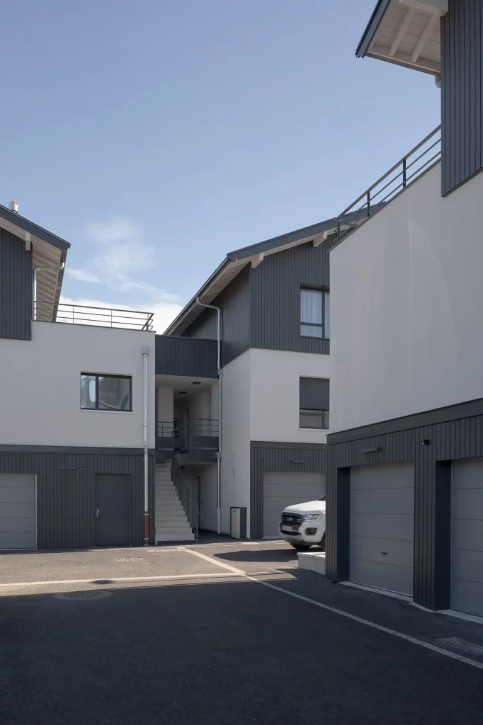 Façade détaillée du complexe résidentiel avec des éléments en verre et métal, reflétant un design moderne et épuré